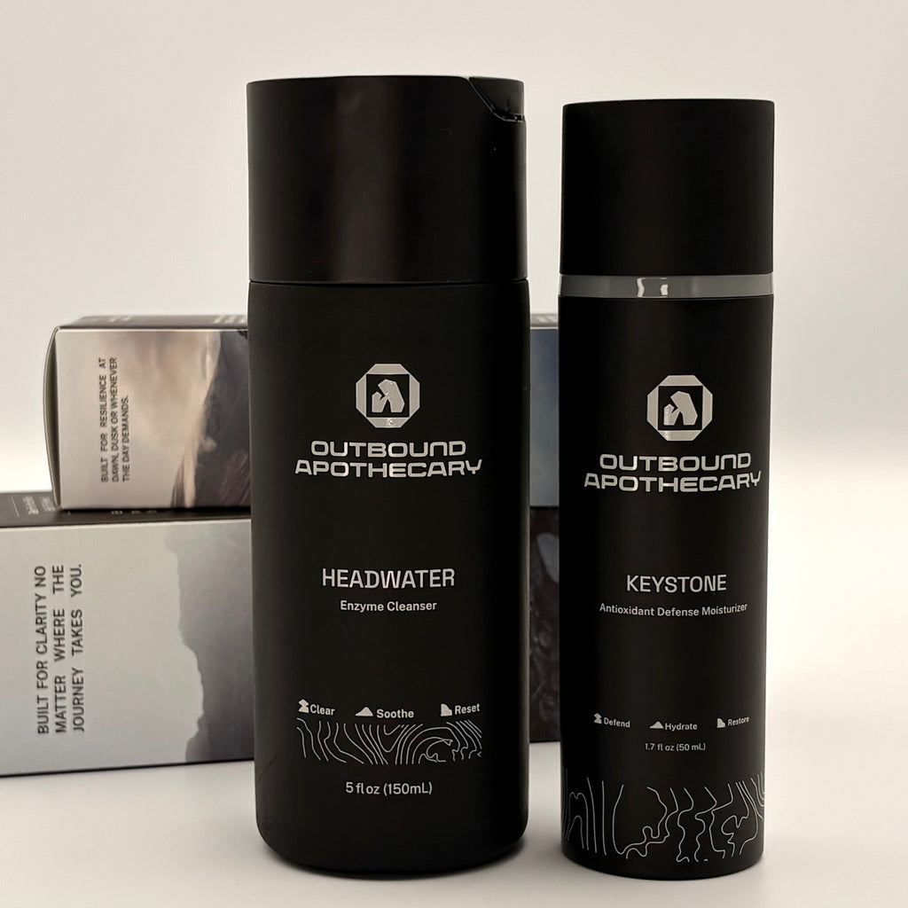 Two black bottles labeled 'Outbound Apothecary' on a light background