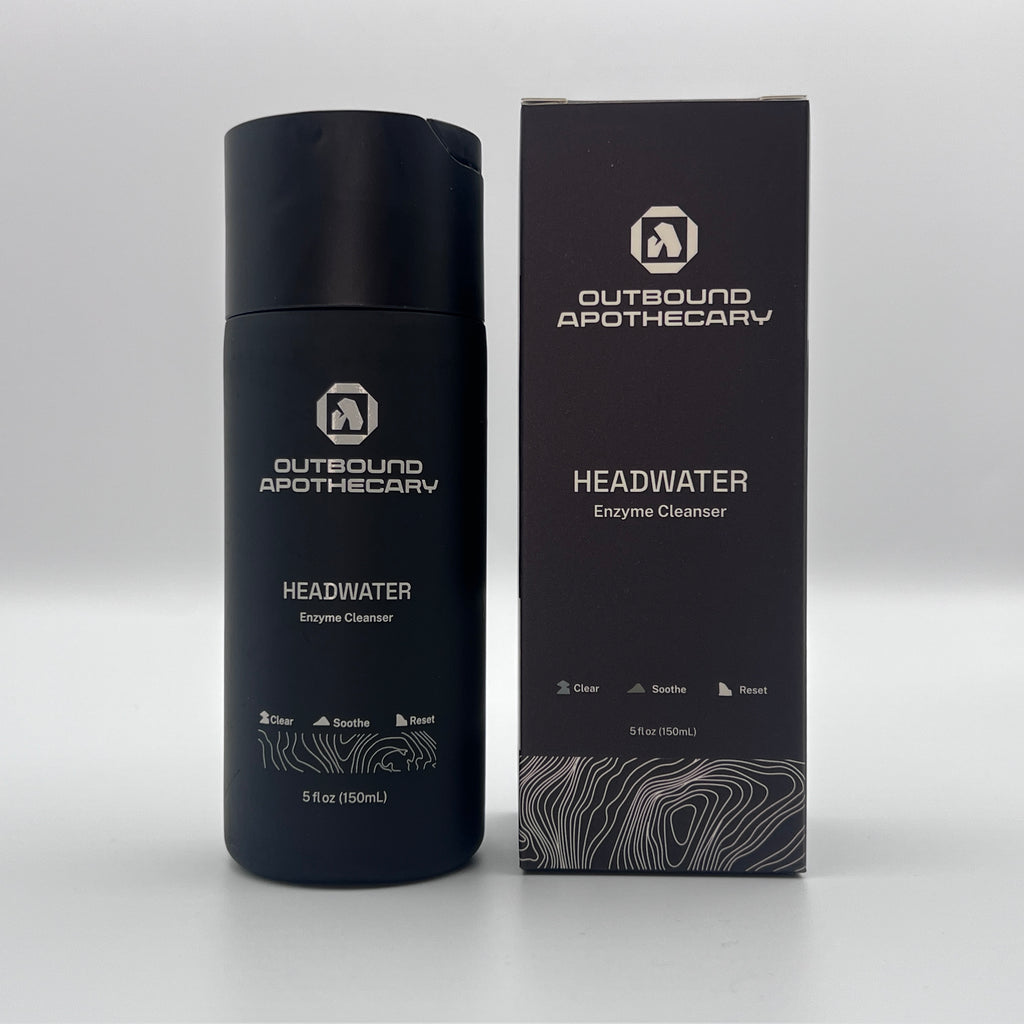 Black bottle and box of Outbound Apothecary Headwater Enzyme Cleanser on a white background